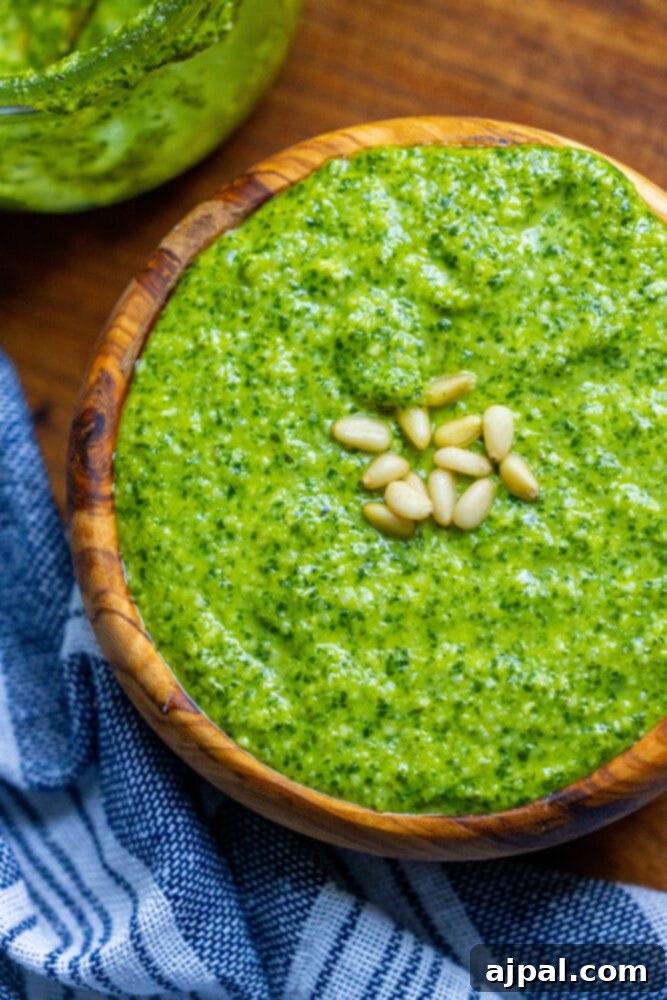 Effortless Vegan Pesto 3 Close-up of creamy vegan pesto in a rustic wooden bowl, showcasing its vibrant green color.
