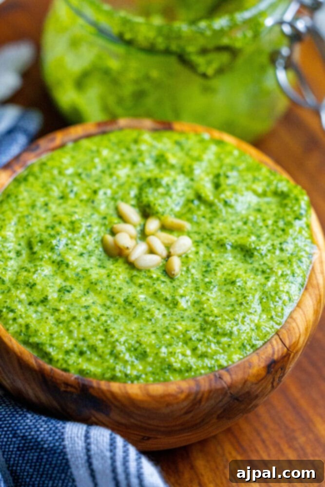 Effortless Vegan Pesto 4 A wooden bowl filled with vibrant green vegan pesto, freshly made.