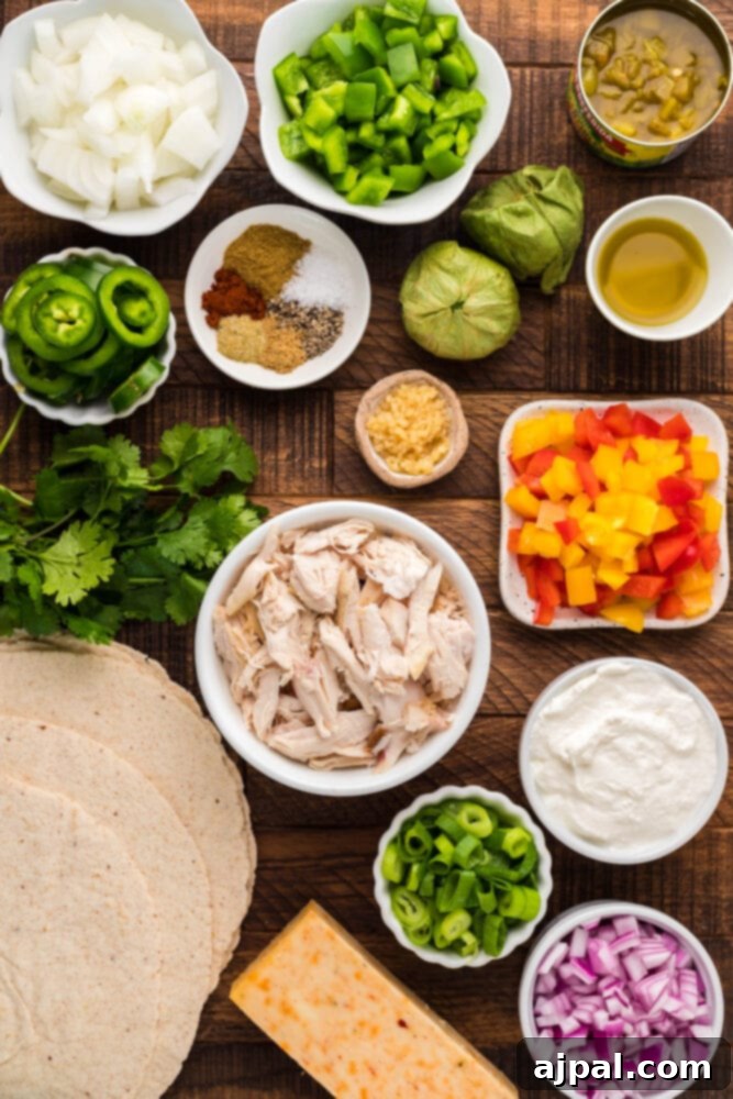 Assorted fresh ingredients for keto enchilada casserole on a table, including chicken, cheese, and vegetables.