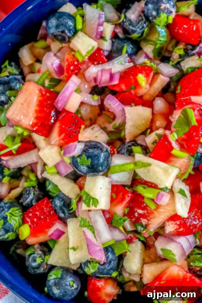 Red White Blue Fruit Salsa 2 Red, white, and blue fruit salsa in a bowl, garnished with fresh cilantro and finely diced red onion.