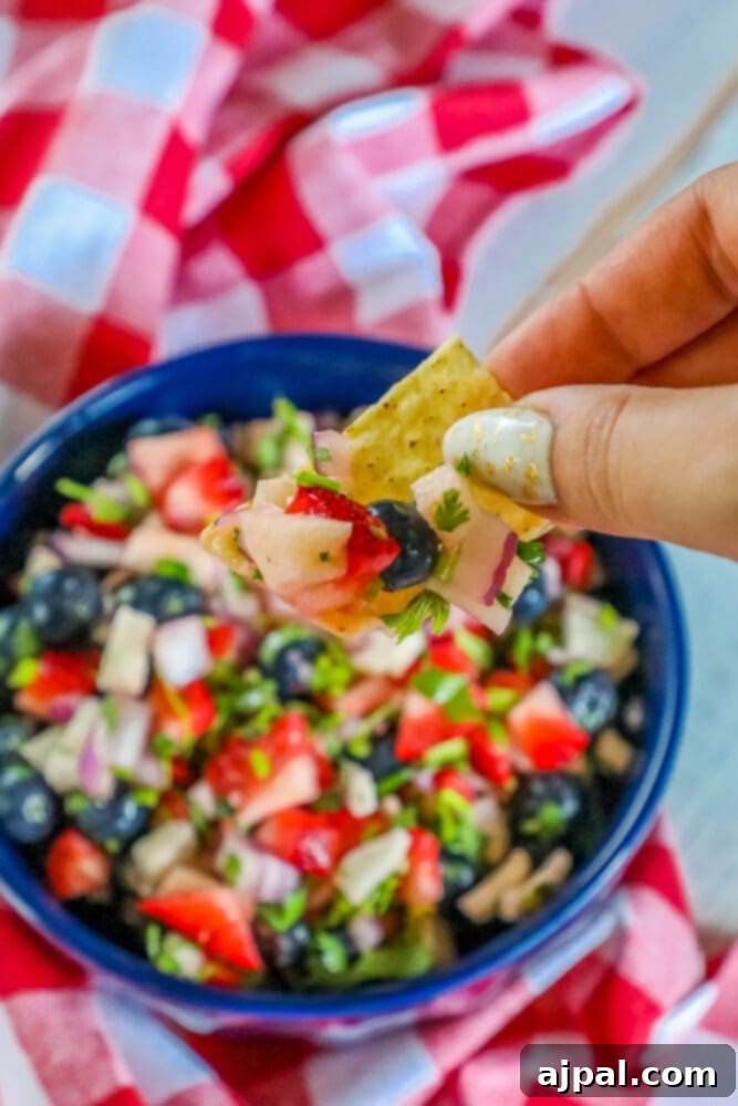 Red White Blue Fruit Salsa 3 A festive 4th of July fruit salsa, in a blue bowl, served with a tortilla chip.