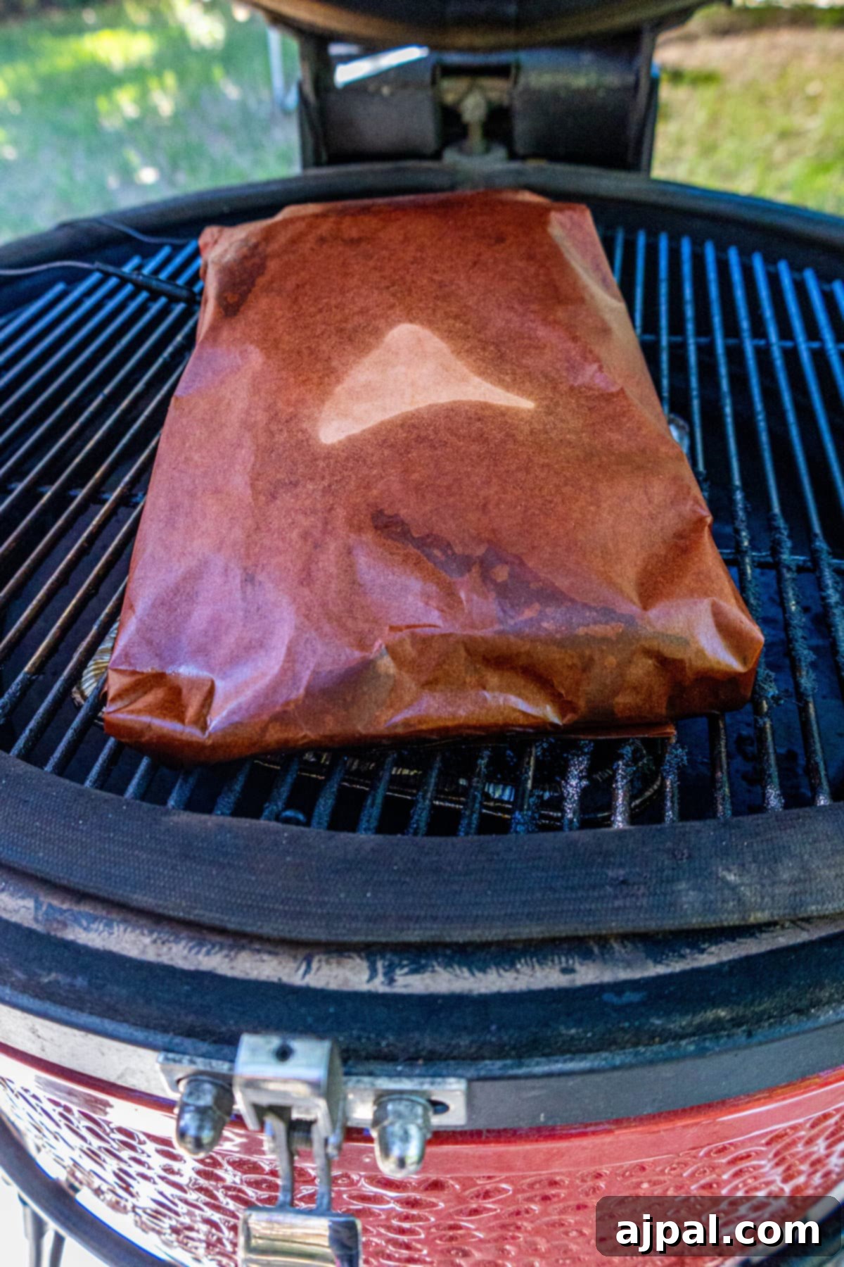 Hot and Fast Brisket Made Easy 7 picture of brisket wrapped in paper on a smoker, continuing to cook