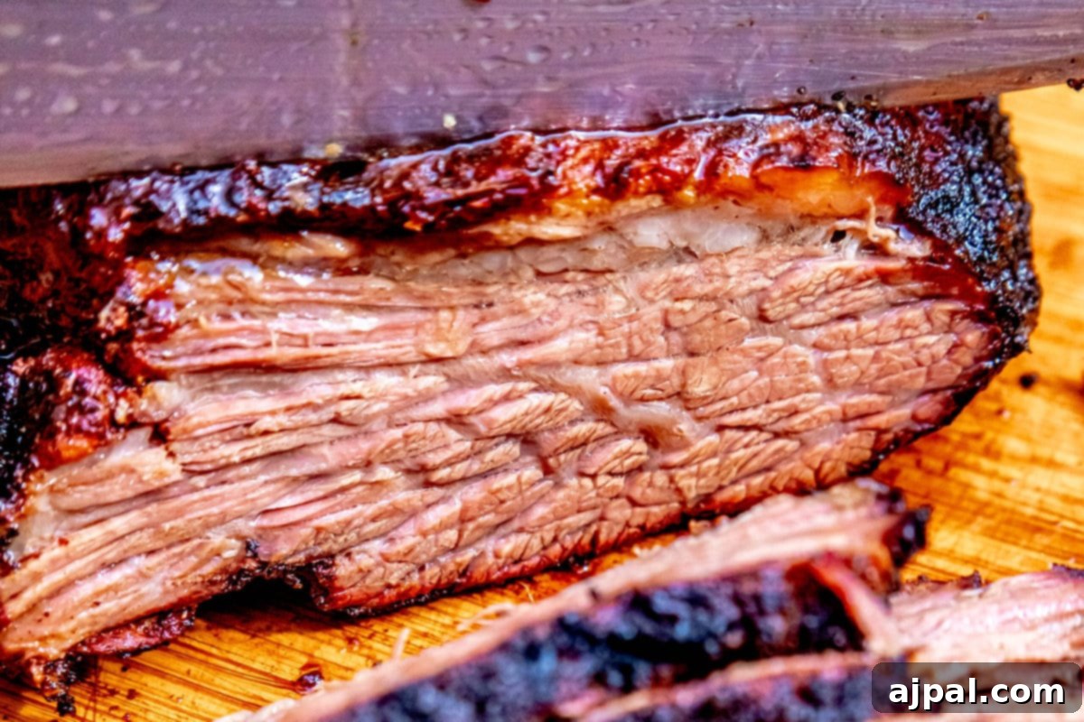 Hot and Fast Brisket Made Easy 9 Fast smoked brisket with a knife on a cutting board, ready to be sliced.