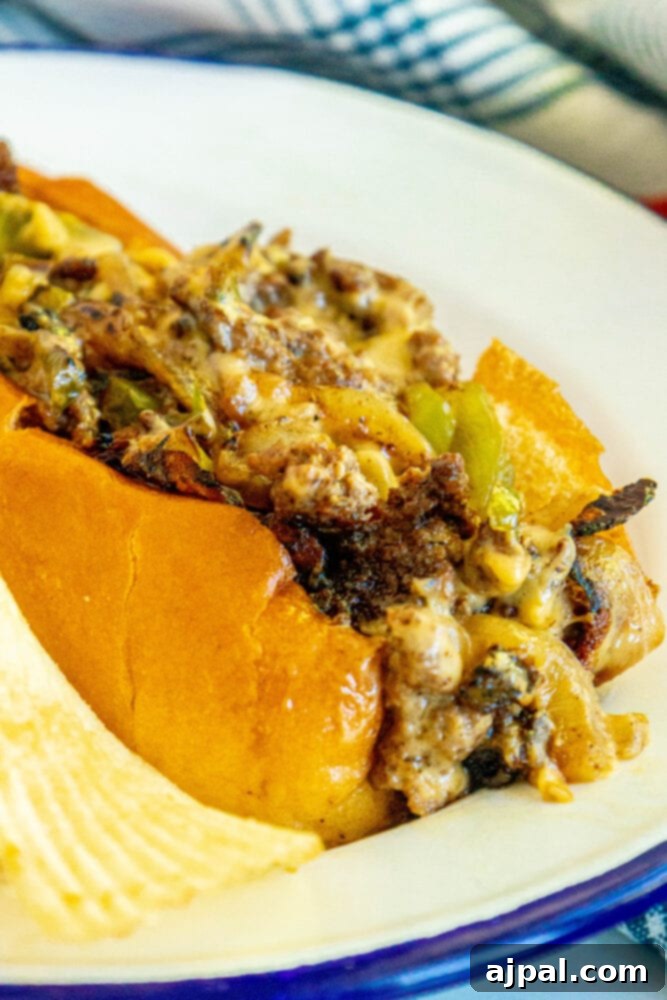 A delicious chopped cheese sandwich, with melted cheese and fresh toppings, ready to eat on a griddle plate.