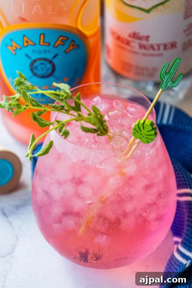 Sunset Sip Blood Orange Gin Tonic 8 Refreshing Malfy Arancia gin and tonic cocktail garnished with a sprig of thyme.