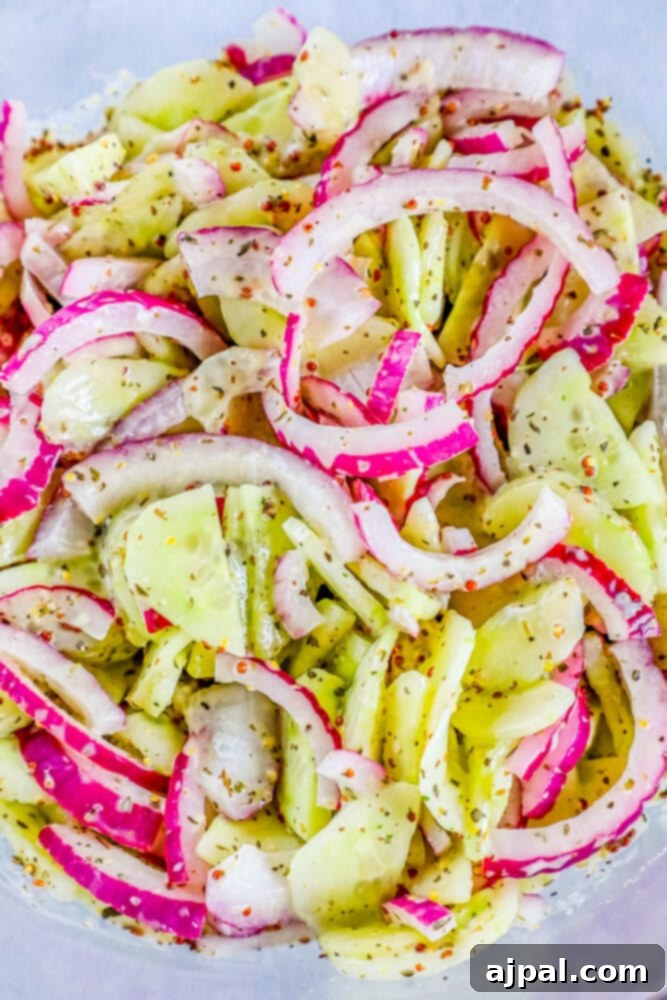 Cool Creamy Cucumber Salad 11 A rustic wooden board holds a vibrant creamy cucumber salad, garnished with thinly sliced radishes and fresh dill sprigs, creating a visually appealing and refreshing dish.