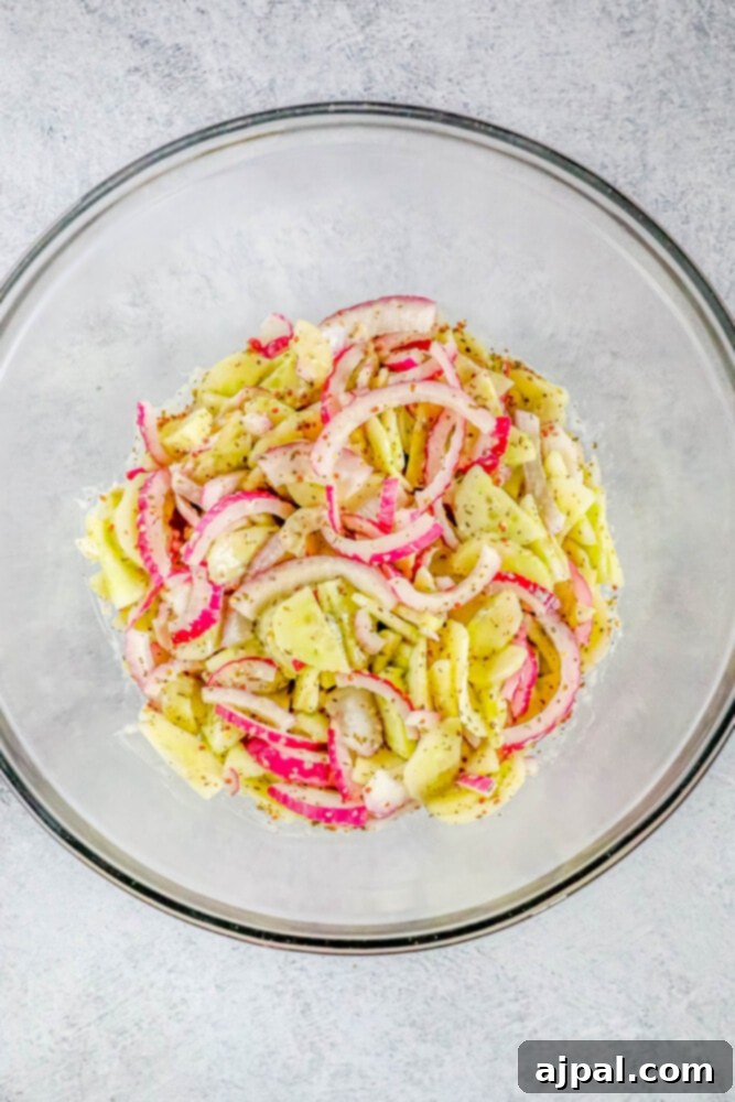 Cool Creamy Cucumber Salad 8 A creamy cucumber salad, freshly mixed and ready to be chilled, in a white bowl, showing even distribution of dressing and vegetables.