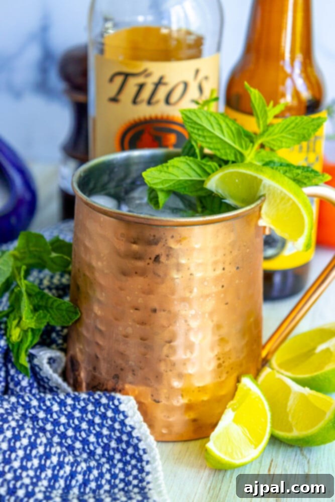 Moscow Mule Zesty Ginger Delight 2 A vibrant Moscow Mule cocktail served in a gleaming copper mug, garnished with fresh mint and a lime wedge, placed on a rustic wooden table.