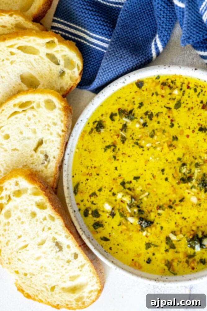 Effortless Bread Dip Perfection 11 An easy bread dip made with olive oil and herbs, served with crusty bread and a stylish blue towel, creating an inviting spread for any occasion.