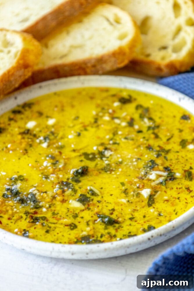 Effortless Bread Dip Perfection 9 A pristine white bowl filled with the homemade olive oil bread dip sits on a rustic wooden surface, highlighting its simple elegance and delicious appeal.