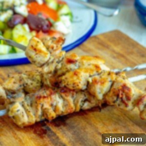 Picture of grilled chicken souvlaki on a skewer on a cutting board