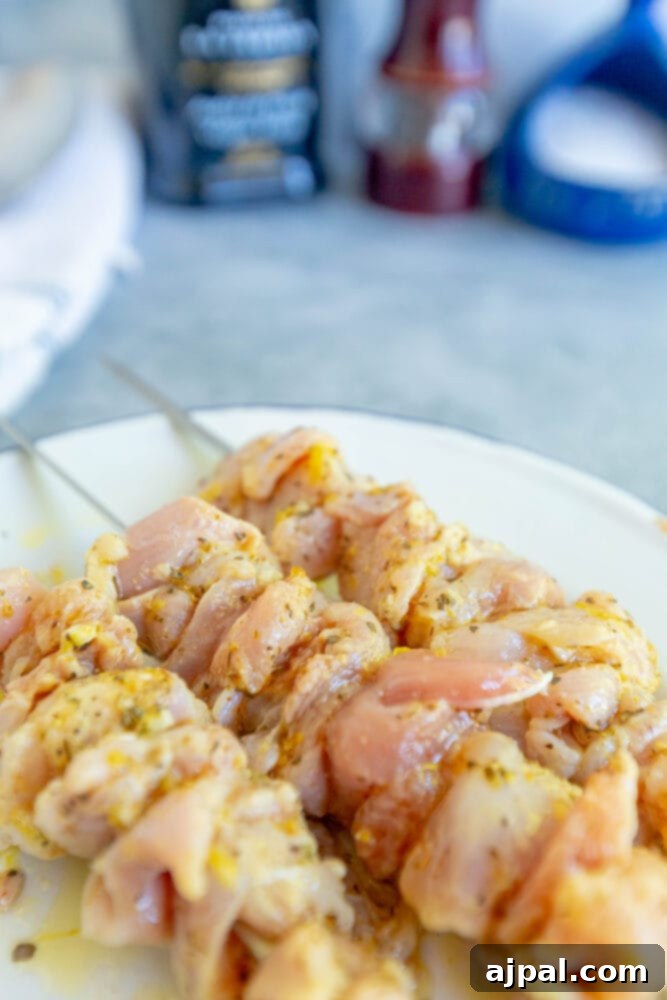 Raw chicken pieces uniformly cut and skewered, waiting to be grilled