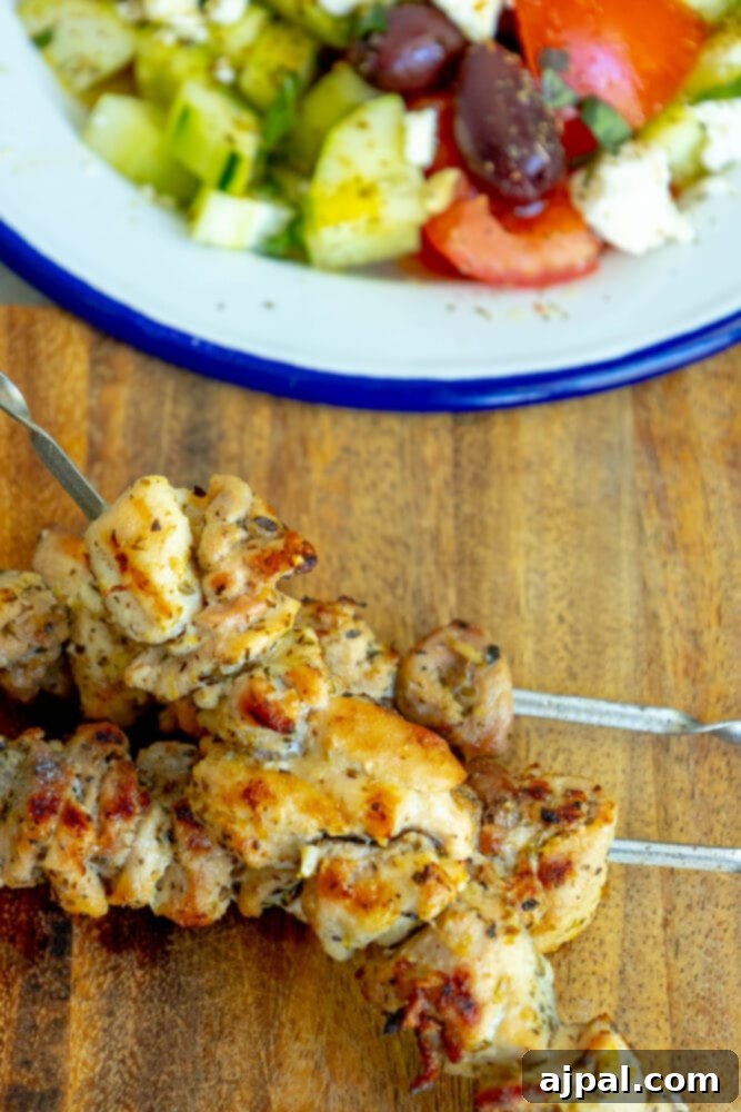 Appetizing grilled chicken souvlaki skewers, garnished with fresh herbs, on a rustic wooden board.