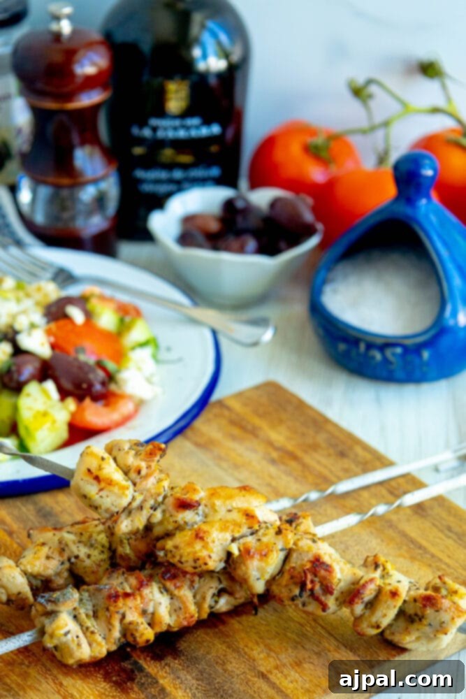 Freshly grilled chicken souvlaki on a wooden cutting board, highlighting the perfect sear and marinade.