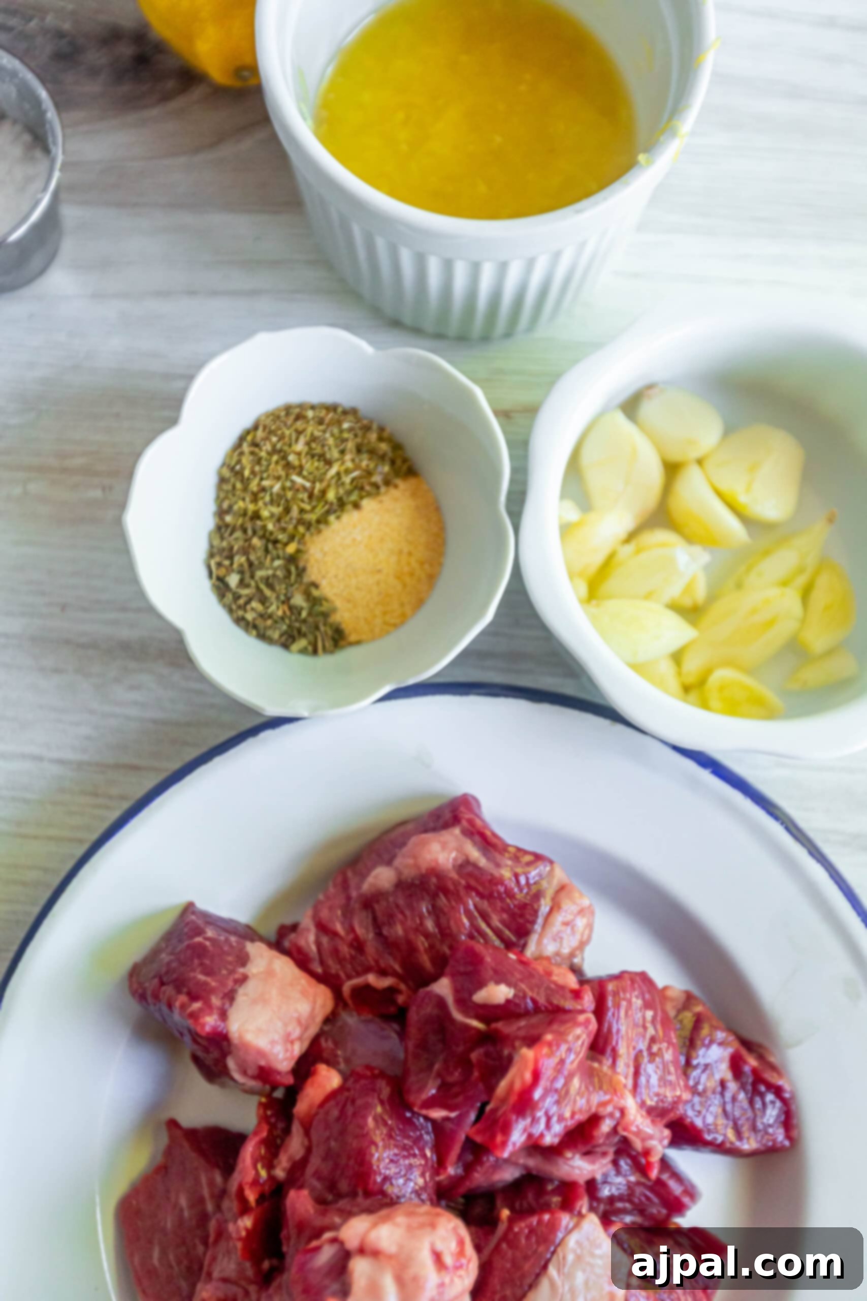 Classic Grilled Lamb Souvlaki Skewers 3 picture of raw lamb, spices, garlic, lemon juice, and olive oil on a table