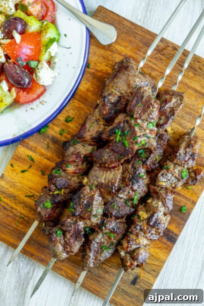 Classic Grilled Lamb Souvlaki Skewers 8 picture of lamb souvlaki on wooden cutting board with chopped cilantro on top
