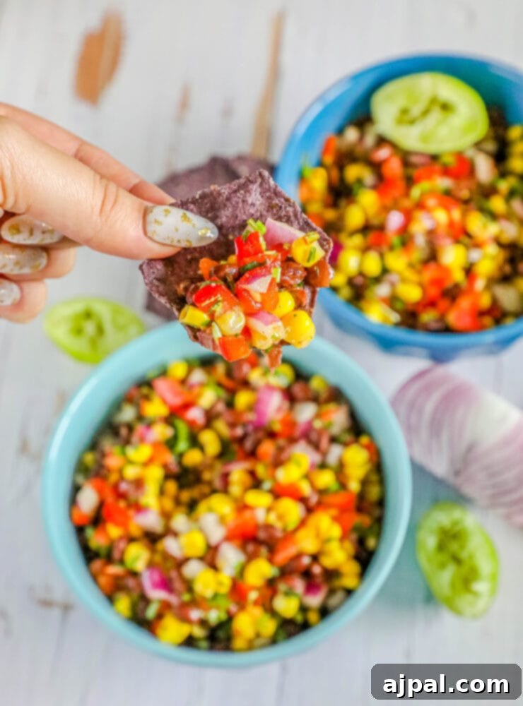 A vibrant bowl of black bean and corn salsa with fresh herbs and bell peppers, ready to be served.