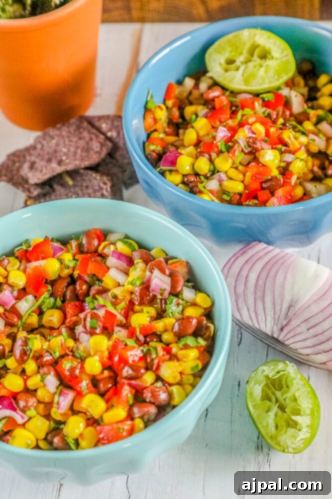 Black bean and corn salsa in a blue bowl, garnished with fresh cilantro, ready to be served.