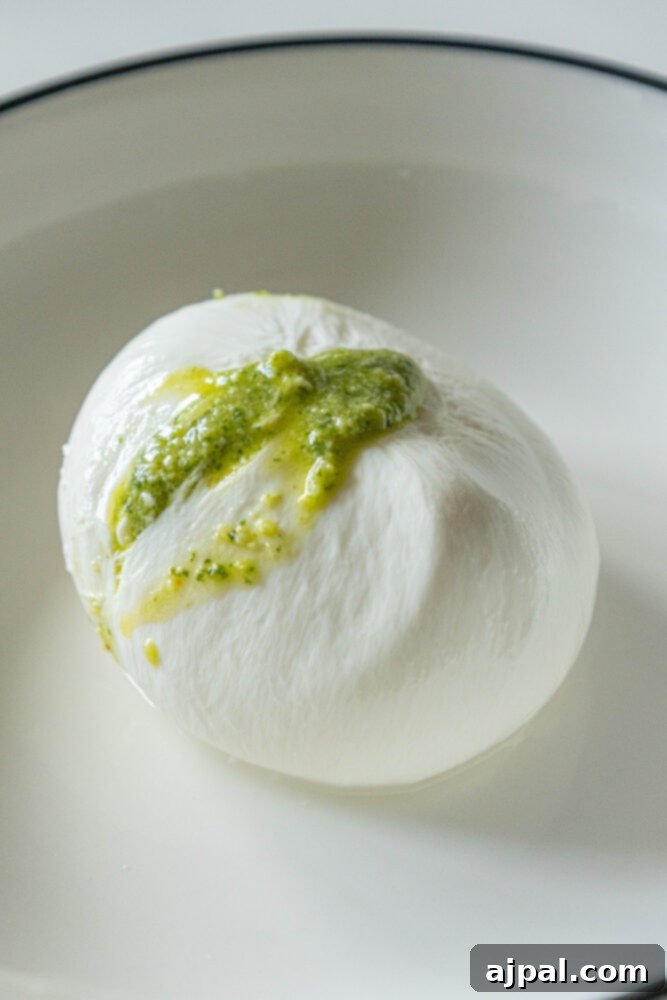 Burrata Bursting with Pesto 6 picture of stuffed burrata with pesto spilling out the top