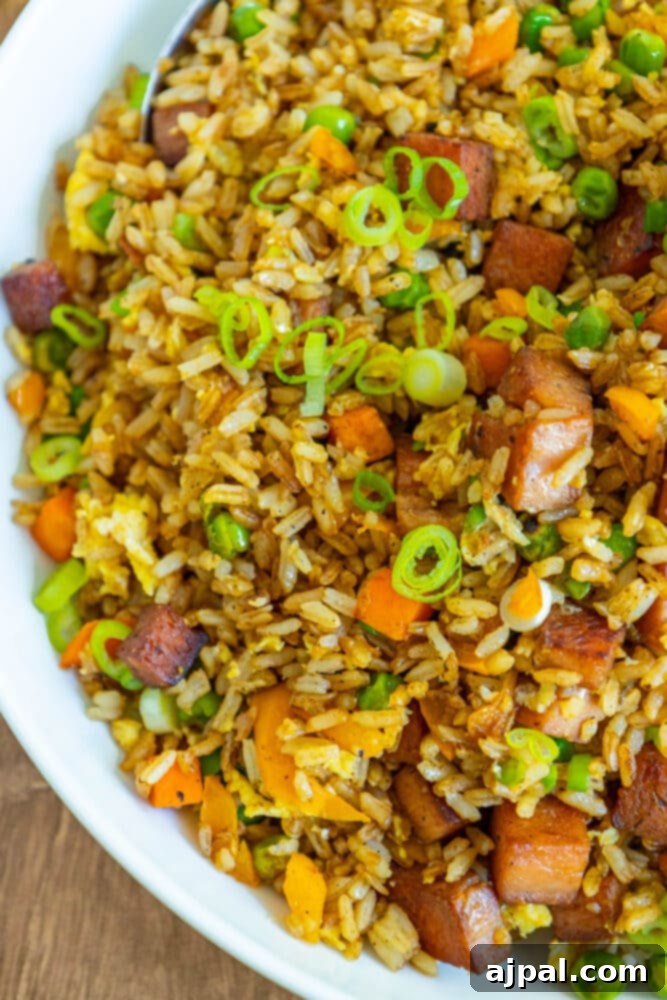 Effortless Spam Fried Rice 2 picture of spam fried rice with peppers, peas, and chopped green onions a bowl