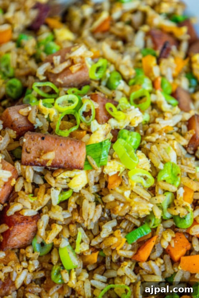 Effortless Spam Fried Rice 12 picture of spam fried rice with peppers, peas, and chopped green onions a bowl