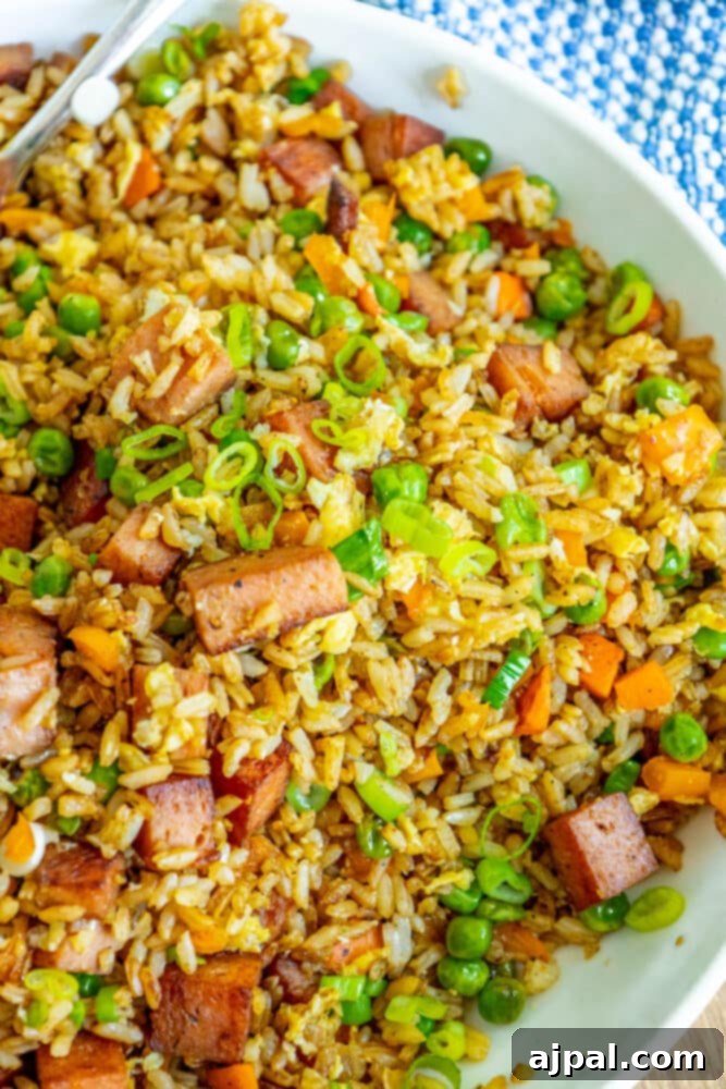 Effortless Spam Fried Rice 13 picture of spam fried rice with peppers, peas, and chopped green onions a bowl