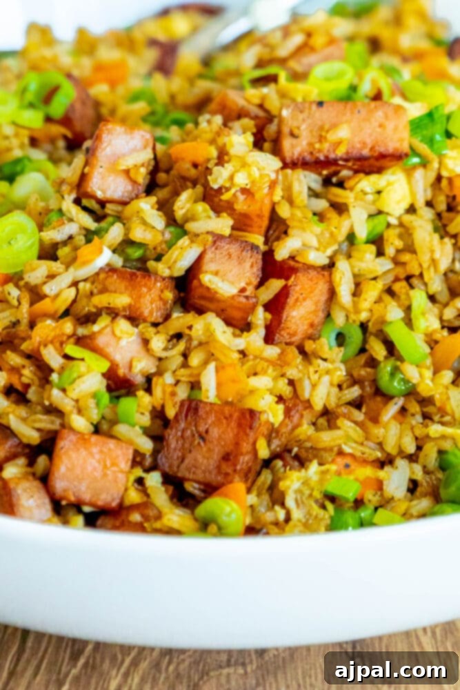 Effortless Spam Fried Rice 14 picture of spam fried rice with peppers, peas, and chopped green onions a bowl