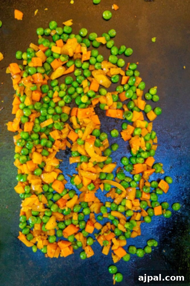 Effortless Spam Fried Rice 6 picture of frozen carrots and peas frying on a griddle