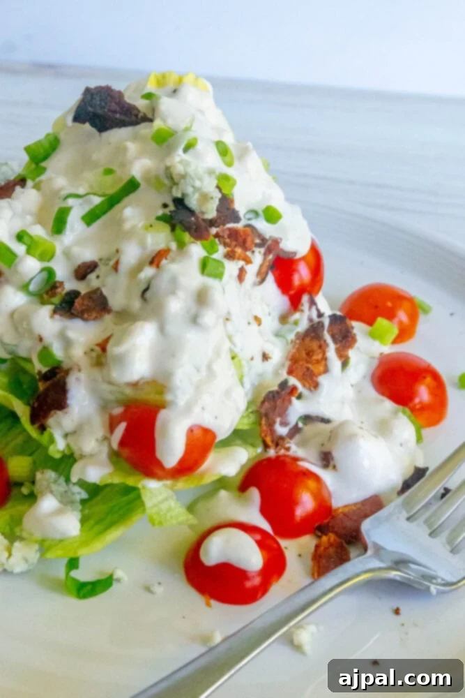 Classic Wedge Salad with Creamy Blue Cheese Dressing 2 Wedge salad with green onions, tomatoes, bacon, and crumbled blue cheese dressing