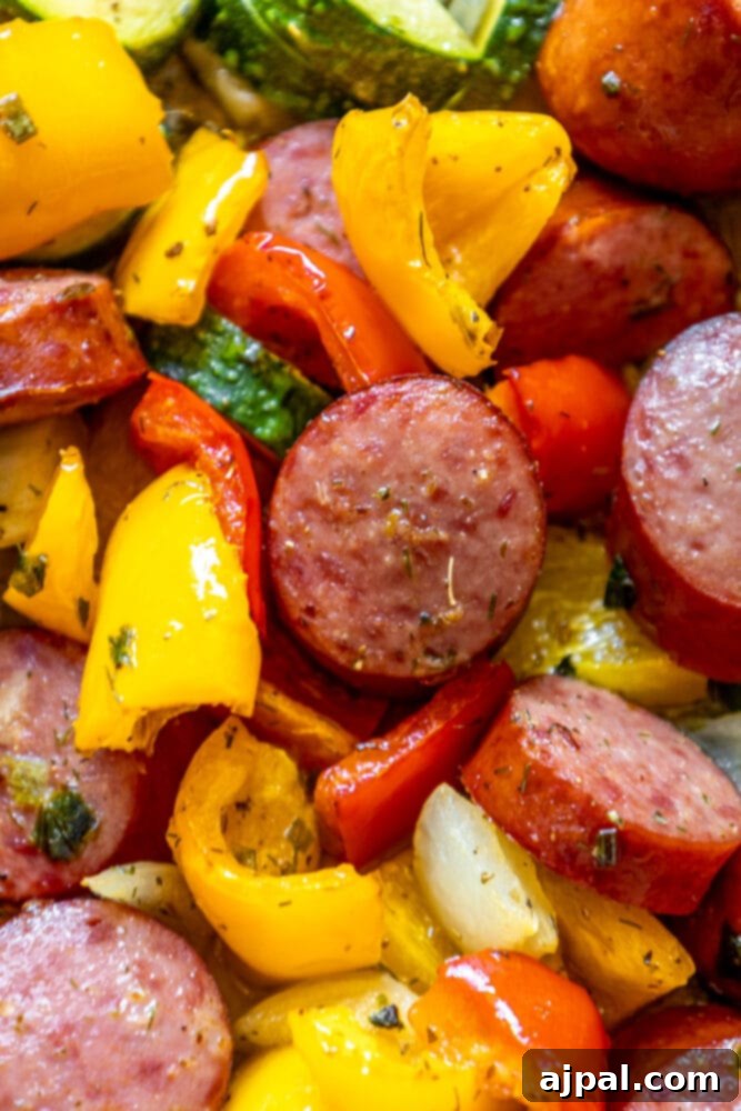 Easy Kielbasa Sheet Pan Dinner 10 picture of turkey kielbasa, bell peppers, onions, and herb dressing baked on a baking sheet on a table