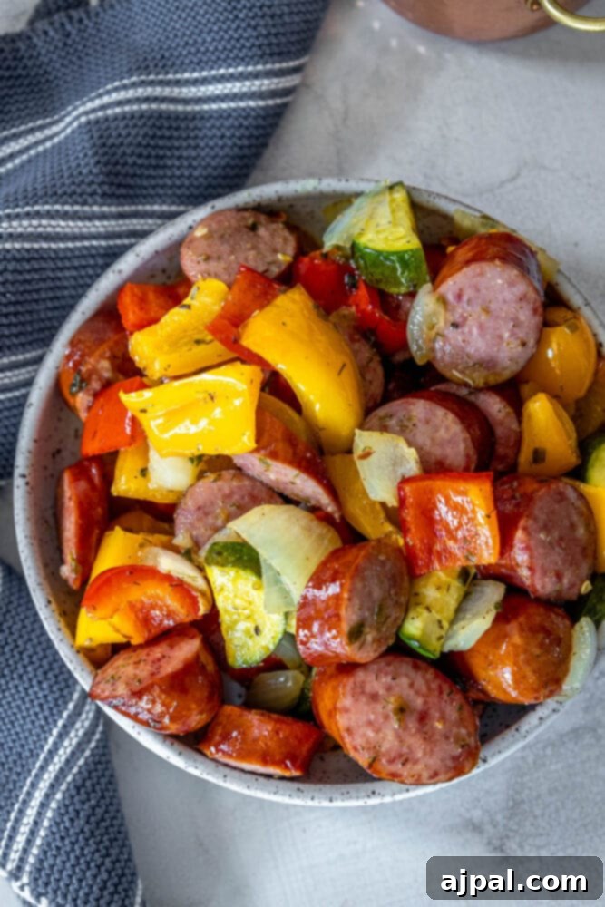 Easy Kielbasa Sheet Pan Dinner 3 picture of turkey kielbasa, bell peppers, onions, and herb dressing baked on a baking sheet on a table