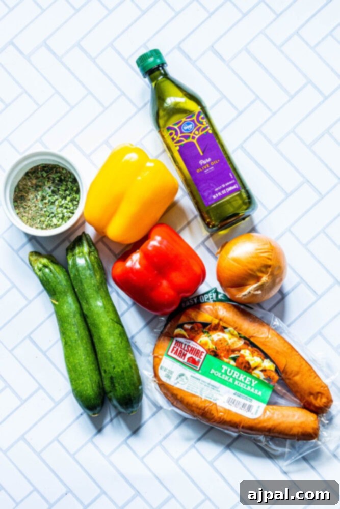 Easy Kielbasa Sheet Pan Dinner 4 picture of zucchini, herbs, bell peppers, olive oil, onion, and turkey kielbasa on a table