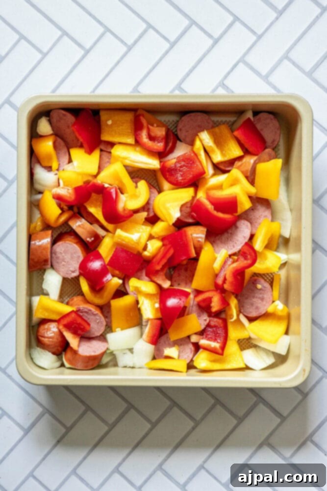 Easy Kielbasa Sheet Pan Dinner 6 picture of sliced turkey kielbasa, onions, and bell peppers in a pan
