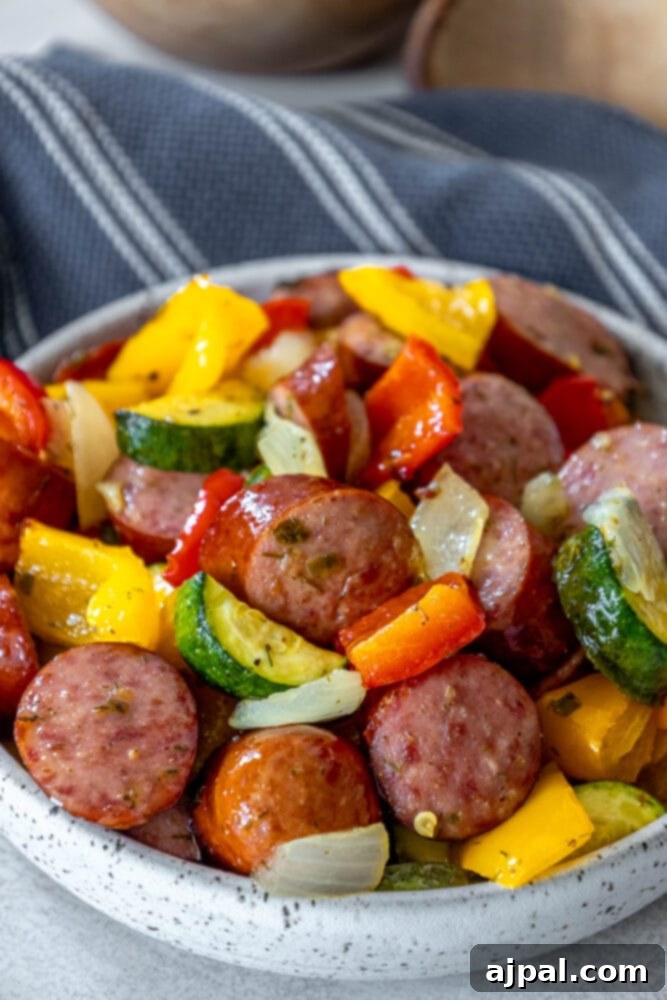 Easy Kielbasa Sheet Pan Dinner 8 picture of turkey kielbasa, bell peppers, onions, and herb dressing baked on a baking sheet on a table