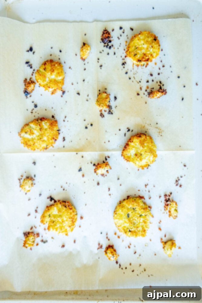 Warm Goat Cheese Bites 11 baked goat cheese balls and garlic cloves rolled in breadcrumbs on a sheet of parchment paper