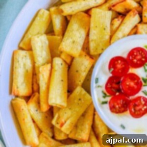 picture of air fried pasta chips in a bowl with feta dip with tomatoes sliced on top