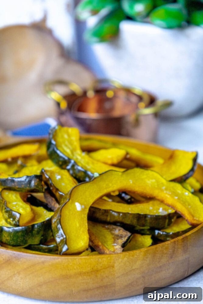 Roasted acorn squash slices artfully arranged on a rustic wooden plate, lightly seasoned with salt, creating a visually appealing side dish.
