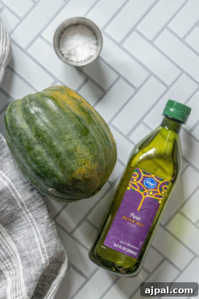 A vibrant selection of acorn squash, olive oil, and coarse salt arranged on a wooden table, showcasing the simple ingredients.