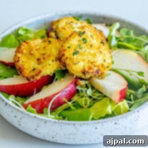 picture of butter lettuce salad with sliced pears and goat cheese balls with champagne vinaigrette dressing on top