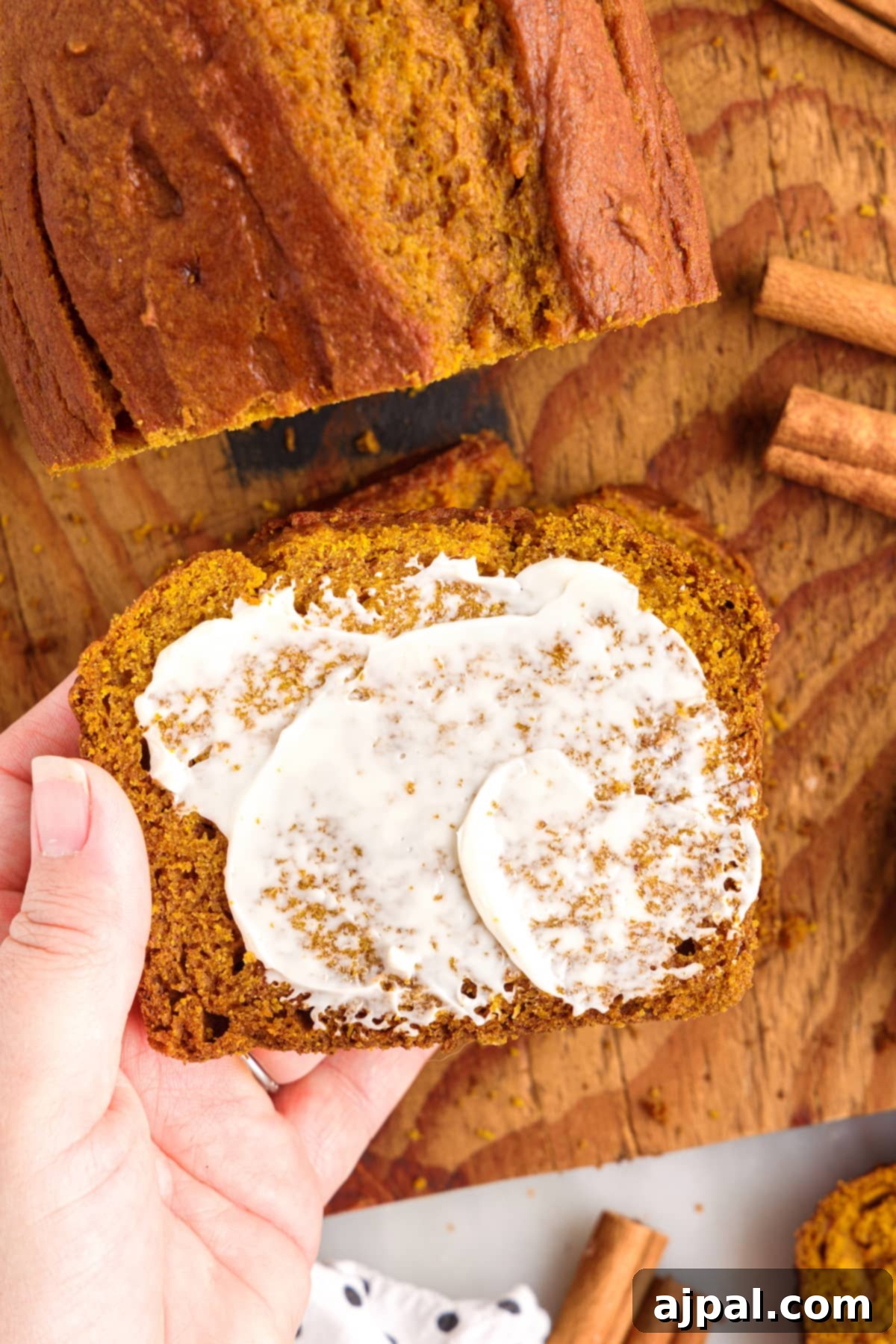 Moist Spiced Pumpkin Loaf 13 A hand is holding the best slice of pumpkin bread.