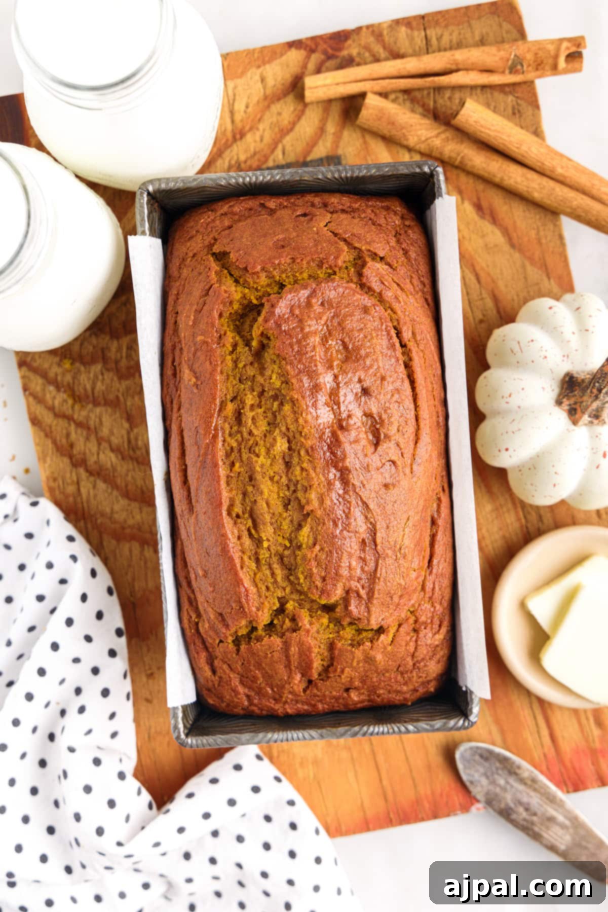 Moist Spiced Pumpkin Loaf 14 A loaf of Easy Pumpkin Bread is sitting on a cutting board.