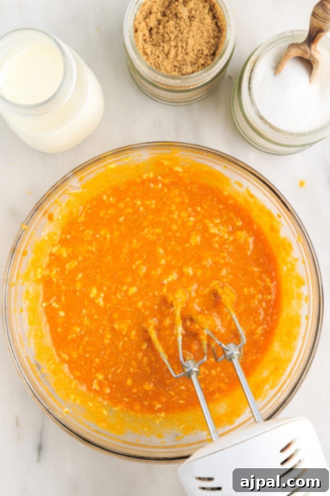 Moist Spiced Pumpkin Loaf 7 picture of pumpkin, milk, butter, and eggs blended in a bowl