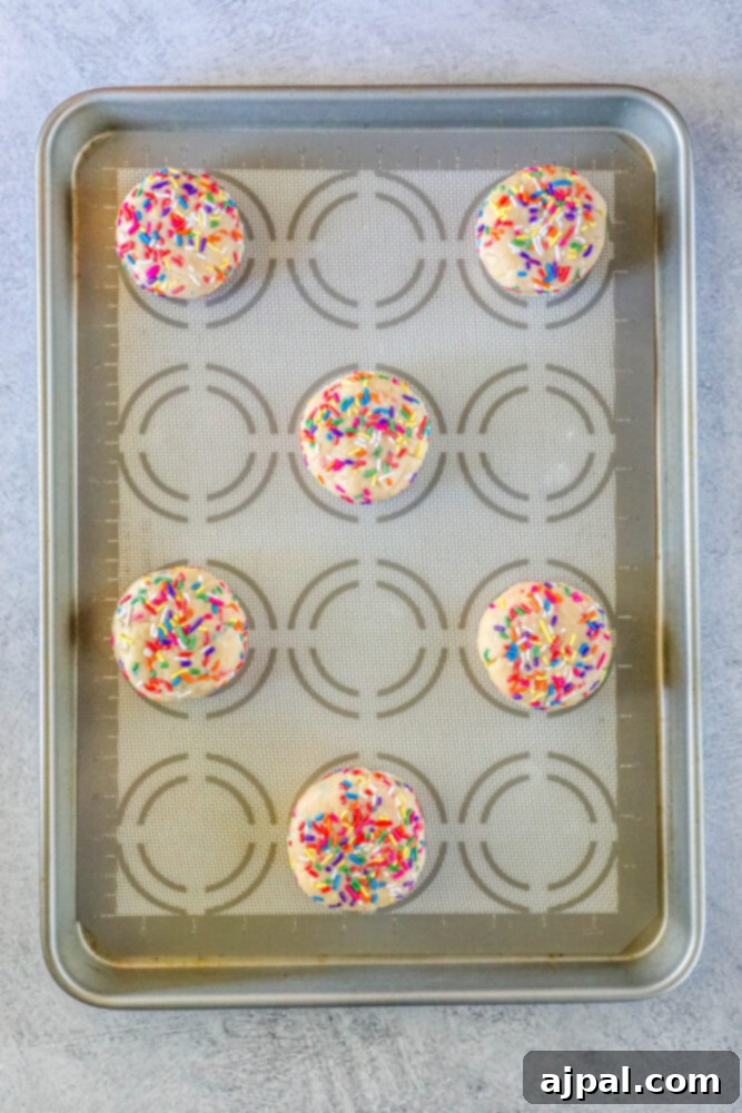 Mega Sprinkle Celebration Cookies 5 Cupcakes in a baking pan with sprinkles on top, resembling jumbo funfetti cookies.