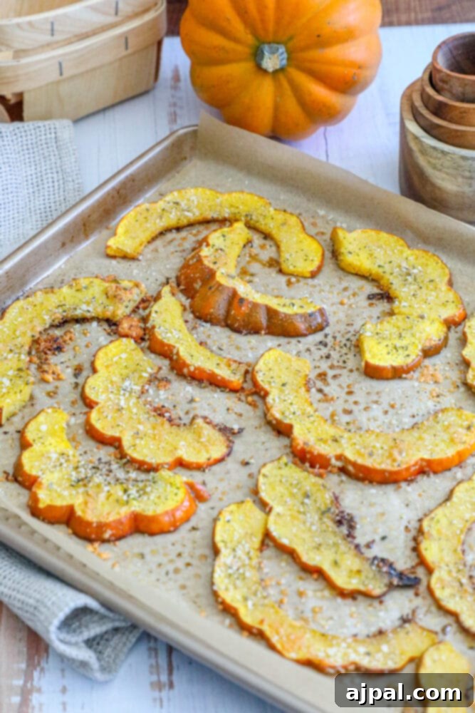 Sliced acorn squash pieces on a baking sheet, ready for seasoning and roasting.