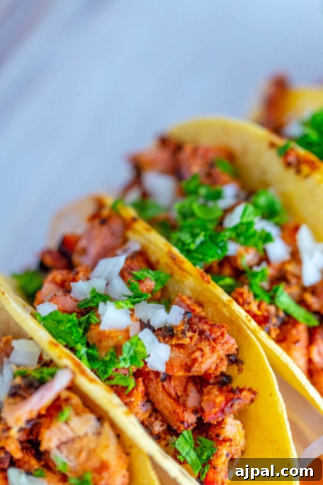 Smoked al pastor chicken tacos on a wooden board.