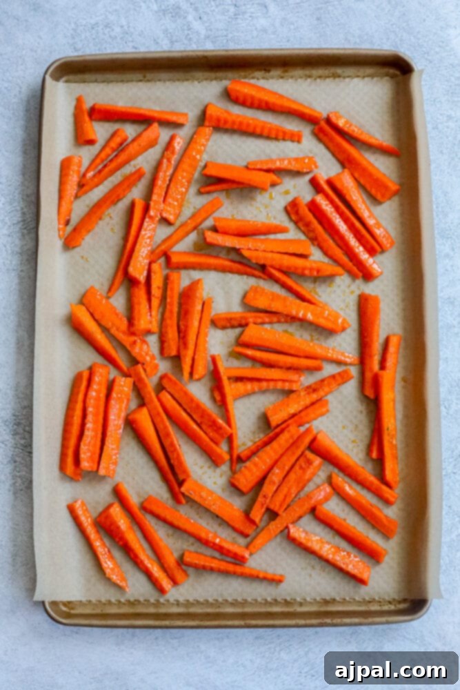 picture of seasoned carrots on a baking sheet lined with parchment paper