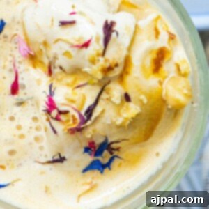 A pristine image of Earl Grey Affogato served in a clear glass, garnished with delicate cornflowers.