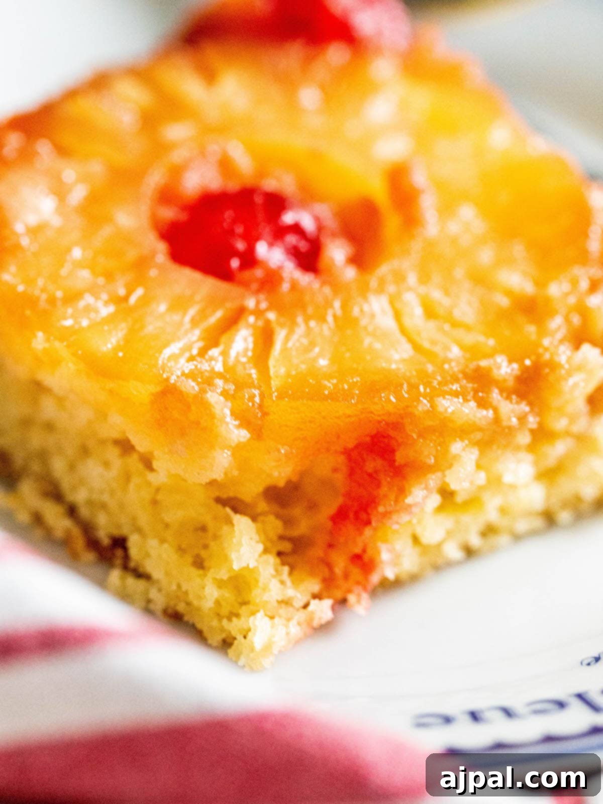 Caramelized Pineapple Bliss 3 picture of a slice of pineapple upside down cake with a pineapples and maraschino cherries baked onto the top
