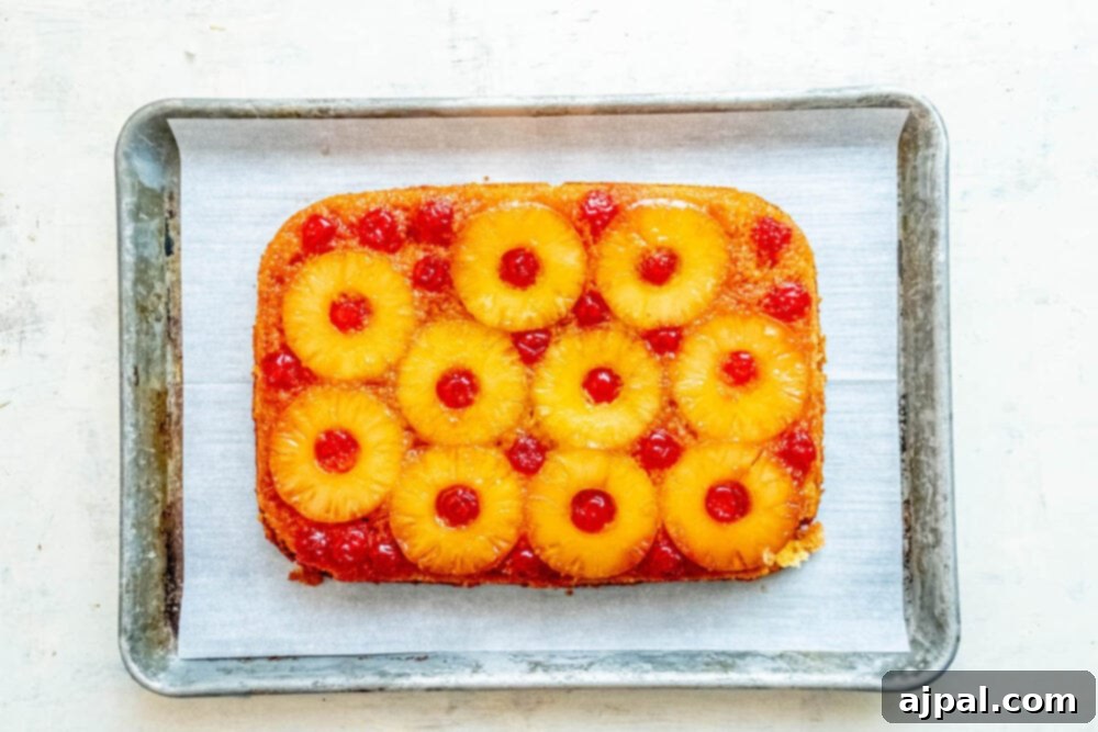 Caramelized Pineapple Bliss 10 picture of baked pineapple upside down cake flipped over on a baking sheet lined with parchment paper
