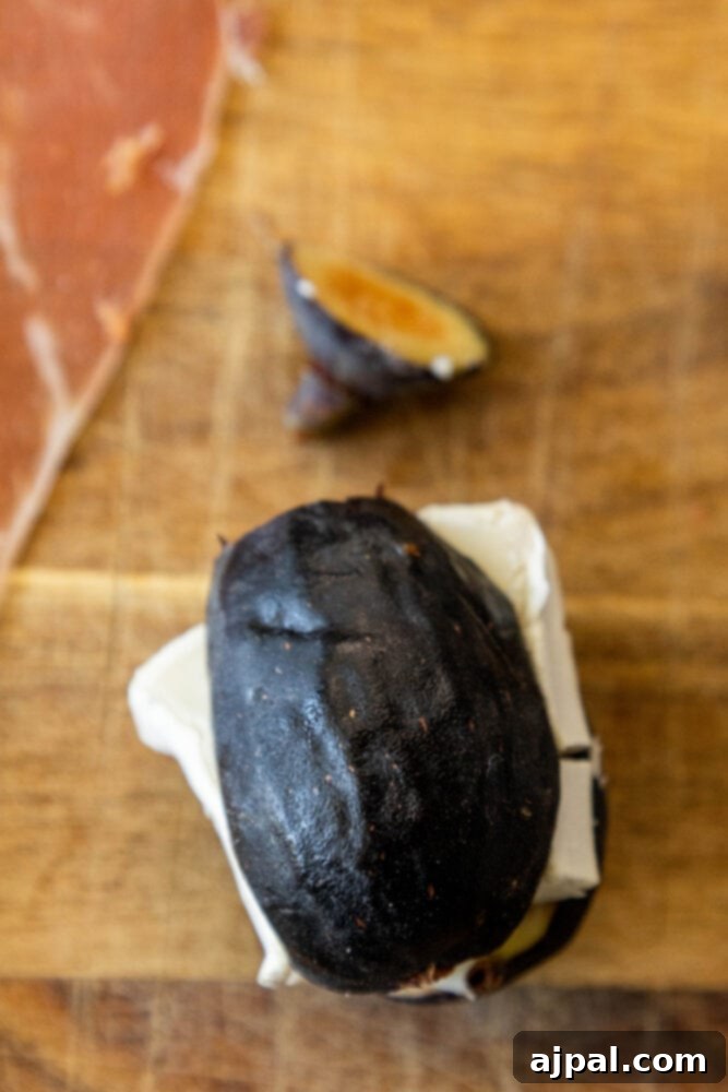 Gourmet Fig, Prosciutto, and Brie Bites 5 Picture of a fig cut in half with a piece of brie cheese carefully stuffed into it